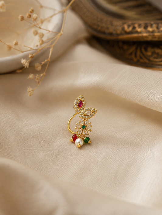 Gold-plated press-on nose ring with CZ stones, ruby red and emerald green accents, and pearl bead hanging.