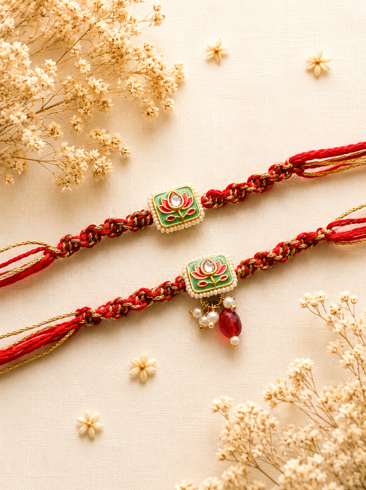 Two handcrafted designer Rakhis featuring square green Meenakari charms with pink lotus motifs, delicate pearl drops, and thick braided red and gold threads.
